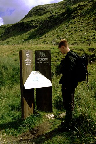 Andrew beside notice board at start of path